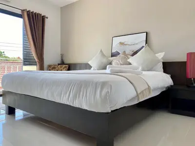 a bedroom with a large bed with white sheets and pillows at SD Residence I Naiyang Beach I HKT Airport in Nai Yang Beach