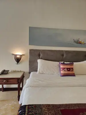 a bedroom with a bed with a desk and a bed sidx sidx sidx at Baan Panwa Resort in Panwa Beach