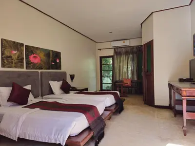 a hotel room with two beds and a piano at Baan Panwa Resort in Panwa Beach
