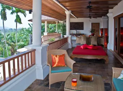 a patio with a table and chairs on a porch at Villa Oriole in Layan Beach