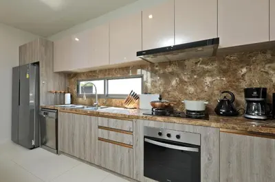a kitchen with white cabinets and stainless steel appliances at Zenithy Pool Villas by Capitalpro ZEN-9 in Phuket Town