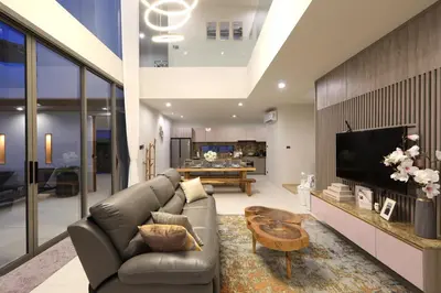 a living room with a couch and a tv at Zenithy Pool Villas by Capitalpro ZEN-9 in Phuket Town