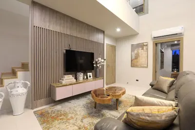 a living room with a couch and a tv at Zenithy Pool Villas by Capitalpro ZEN-9 in Phuket Town