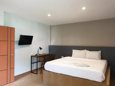 a bedroom with a bed and a tv on a wall at My Friend's House Villa in Karon Beach
