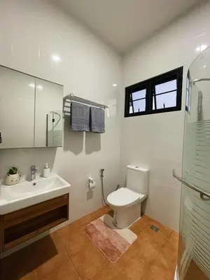 a bathroom with a toilet and a sink and a mirror at Liang's Home เหลียงโฮม in Ban Riang