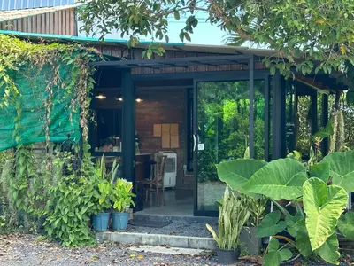 a house with a glass door in a garden at Liang's Home เหลียงโฮม in Ban Riang