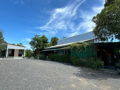 a building with a garage with a tree next to it at Liang's Home เหลียงโฮม in Ban Riang