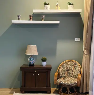 a chair sitting next to a table with a lamp at Liang's Home เหลียงโฮม in Ban Riang