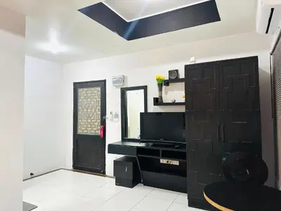 a living room with a television and a black door at Beachwalk Patong in Patong Beach