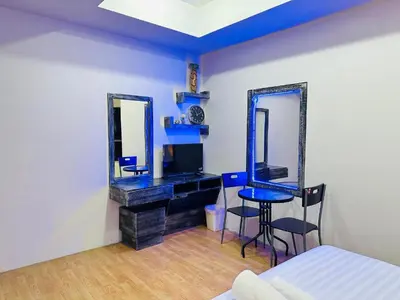 a room with a bed and a desk and mirrors at Beachwalk Patong in Patong Beach