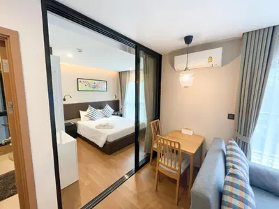 a hotel room with a bed and a table at The Title V Condos by Gregory in Rawai Beach