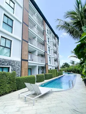 a swimming pool in front of a building at The Title V Condos by Gregory in Rawai Beach