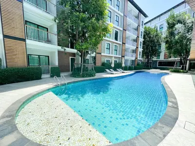 a swimming pool in front of a building at The Title V Condos by Gregory in Rawai Beach