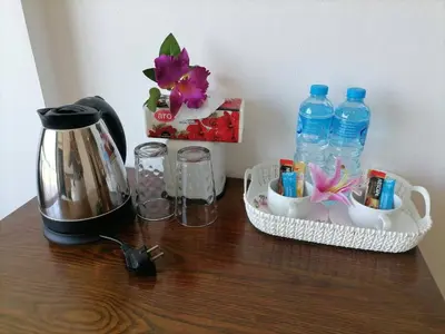 a table with a coffee maker and a tea pot and water bottles at NJ PATONG HOTEL in Patong Beach