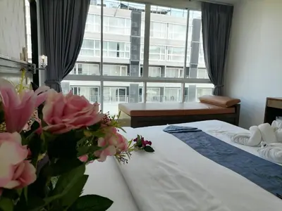 a hotel room with a bed and a large window at NJ PATONG HOTEL in Patong Beach