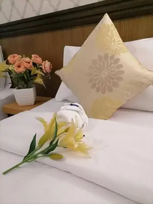 two beds with flowers and a pillow on them at NJ PATONG HOTEL in Patong Beach