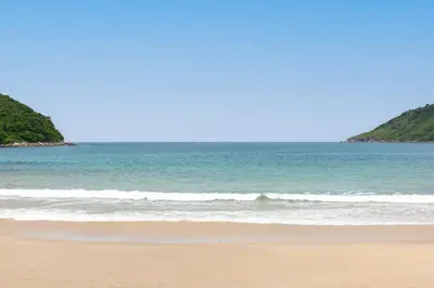 a beach with the ocean in the background at Onyx Villas by TropicLook in Nai Harn Beach