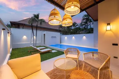 a living room with a couch and chairs and a swimming pool at Onyx Villas by TropicLook in Nai Harn Beach