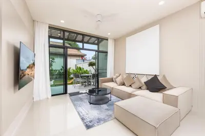 a living room with a couch and a table at Onyx Villas by TropicLook in Nai Harn Beach