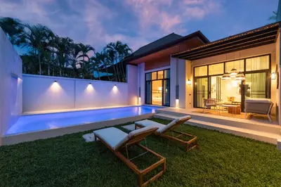 a backyard with a swimming pool and a house at Onyx Villas by TropicLook in Nai Harn Beach