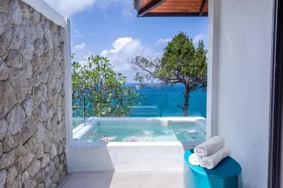 a bathroom with a tub with a view of the ocean at Villa La Prana in Phuket Town