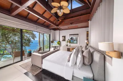 a bedroom with a bed and a ceiling fan at Villa La Prana in Phuket Town