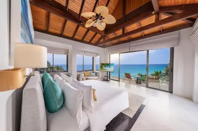a living room with a white couch and a view of the ocean at Villa La Prana in Phuket Town