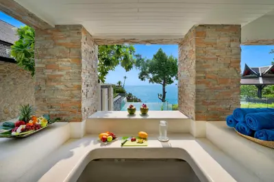 a room with a tub with a view of the ocean at Villa La Prana in Phuket Town