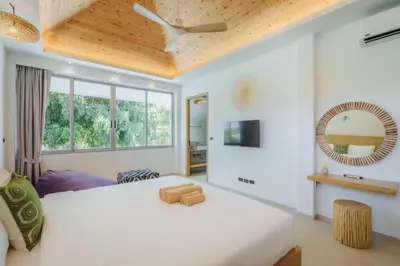 a bedroom with a large white bed and a window at Modern Rustic 4 Bedrooms Villa, Walk to Rawai & Yanui Beach in Nai Harn Beach