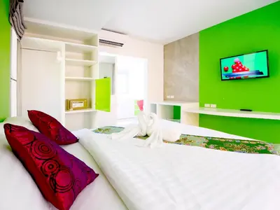 a bedroom with a large white bed with red pillows at Forest Bungalows & Mama's Restaurant in Chalong