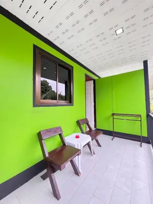 a green room with two chairs and a table at View Garden Resort in Phi Phi Don