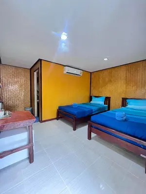 a hotel room with two beds and a table at View Garden Resort in Phi Phi Don