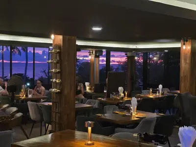 a restaurant with tables and chairs at night at Oceanview Bungalows by EAT in Karon Beach