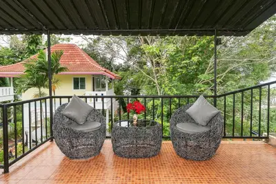 three chairs sitting on a porch with a fence at Oceanview Bungalows by EAT in Karon Beach