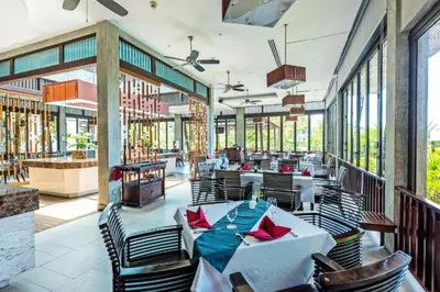 a restaurant with tables and chairs and windows at Club Wyndham Sea Pearl Phuket in Patong Beach