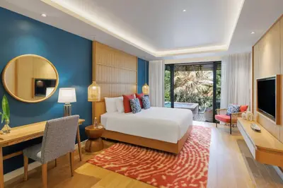 a bedroom with a bed and a desk and a television at Club Wyndham Sea Pearl Phuket in Patong Beach