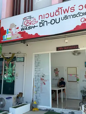 a man sitting at a table outside of a restaurant at Great Hill Jungle View Pool Gym Naiyang in Nai Yang Beach