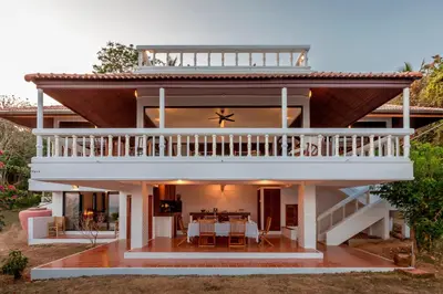 a house with a large deck and a dining room at Baan Khunying - Secluded Phuket Beachfront Villa in Rawai Beach