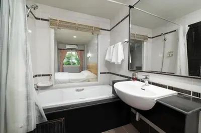 a bathroom with a sink and a tub and a mirror at GP House Phuket Patong Beach in Patong Beach
