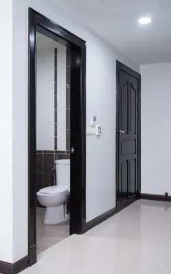 a bathroom with a toilet and a black door at GP House Phuket Patong Beach in Patong Beach