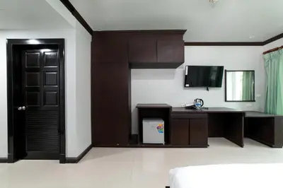 a room with a door and a desk and a television at GP House Phuket Patong Beach in Patong Beach