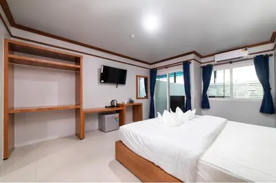a bedroom with a white bed and a tv at GP House Phuket Patong Beach in Patong Beach