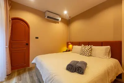 a bedroom with a bed with towels on it at Cozy Patong Beach House 3 Bedrooms in Patong Beach