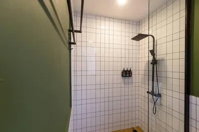 a shower in a bathroom with white tile at Cozy Patong Beach House 3 Bedrooms in Patong Beach