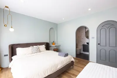 a bedroom with a large white bed and a door at Cozy Patong Beach House 3 Bedrooms in Patong Beach