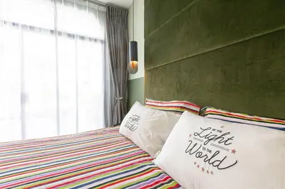 a bed with a pillow that says it cuts the world at Cozy Patong Beach House 3 Bedrooms in Patong Beach