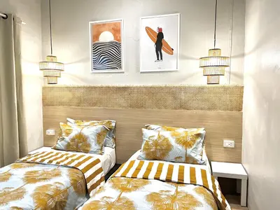 two beds in a room with pictures on the wall at Surfer House Patong Center 3 Bedrooms in Patong Beach