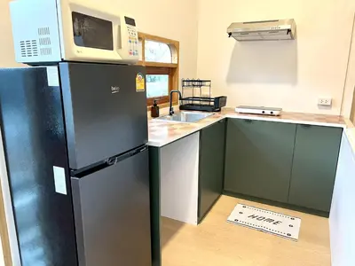 a kitchen with a black refrigerator and a microwave at Surfer House Patong Center 3 Bedrooms in Patong Beach