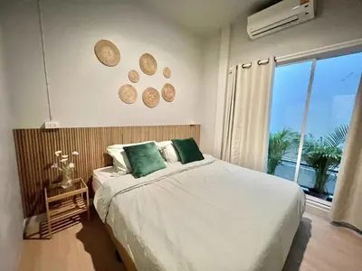 a bedroom with a bed and a window with a view at Surfer House Patong Center 3 Bedrooms in Patong Beach