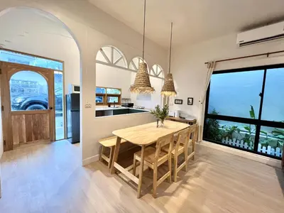 a kitchen with a wooden table and a large window at Surfer House Patong Center 3 Bedrooms in Patong Beach